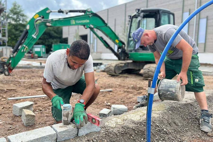 Zwei Gartenexperten arbeiten an einem Fundament