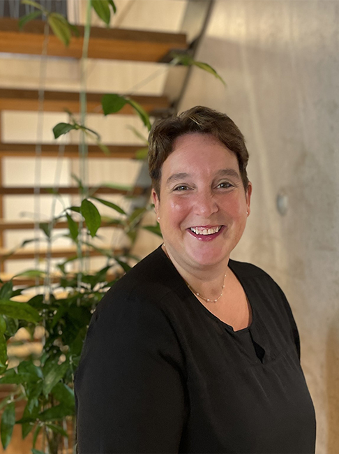 Portrait einer Frau in schwarzer Bluse vor einer Zimmerpflanze