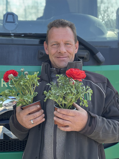 Portrait eines Gartenexperten, der zwei Blumentöpfe in den Händen hält