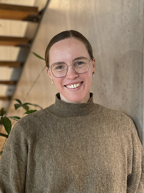 Portrait einer lächelnden, jungen Frau mit Brille